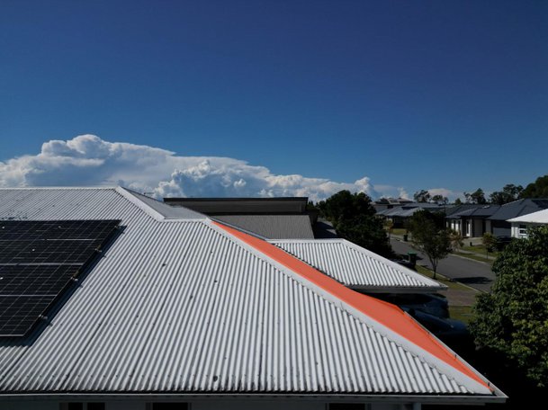 Too high, drone angled down, sheeting visible past the hip flashing